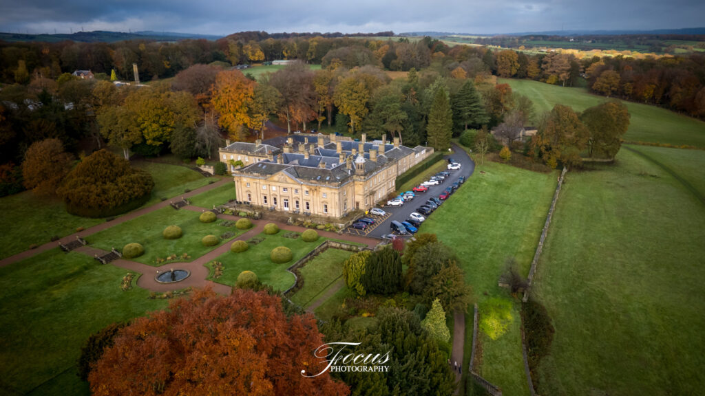 Aerial view of grand estate and gardens in autumn.